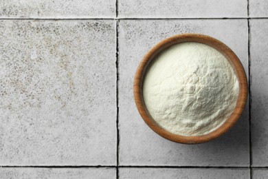 Bowl of agar-agar powder on tiled table, top view. Space for text