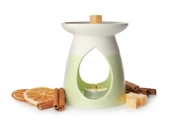 Photo of Stylish aroma lamp with essential wax cubes, dried orange slices and cinnamon on white background