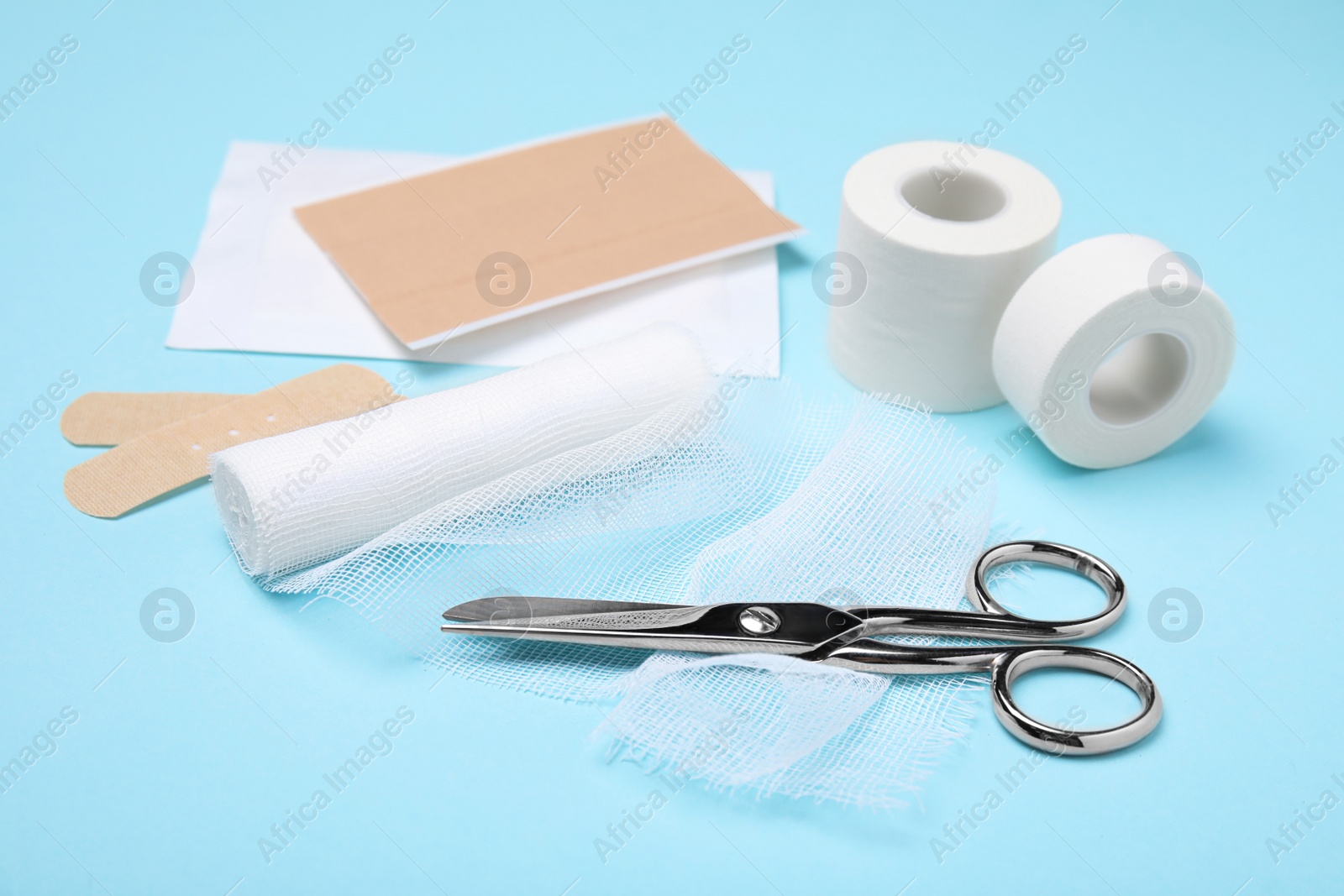 Photo of White bandage and medical supplies on light blue background