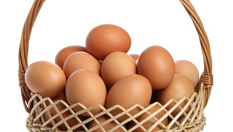 Chicken eggs in wicker basket isolated on white