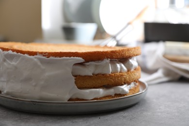 Delicious homemade layer cake with cream on grey table, closeup