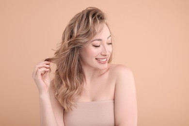 Portrait of smiling woman on beige background