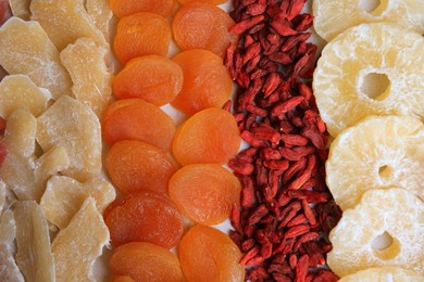 Different tasty dried fruits as background, top view