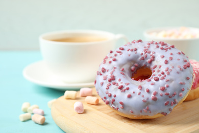 Delicious glazed donuts on blue wooden table, closeup