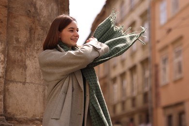 Photo of Beautiful woman in warm scarf on city street