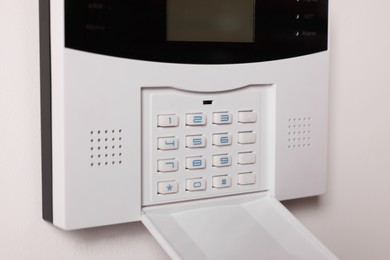 Photo of Home security alarm system on white wall, closeup