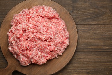 Photo of Raw fresh minced meat on wooden table, top view. Space for text