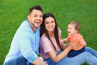 Photo of Happy family with adorable little baby outdoors