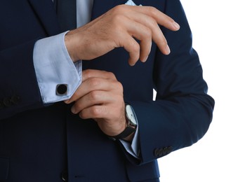 Photo of Stylish man putting on cufflink against white background, closeup