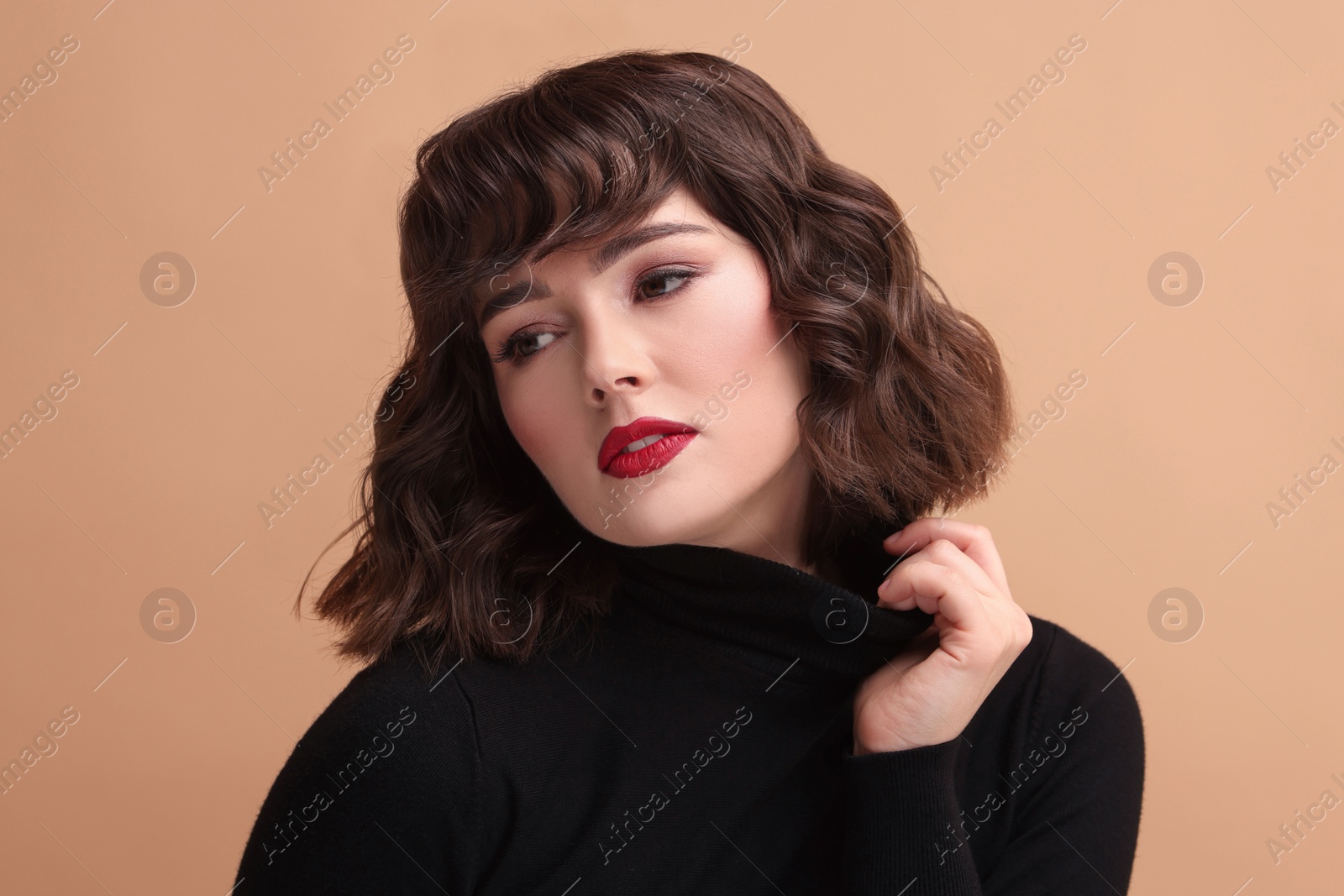 Photo of Portrait of beautiful young woman with wavy hairstyle on beige background