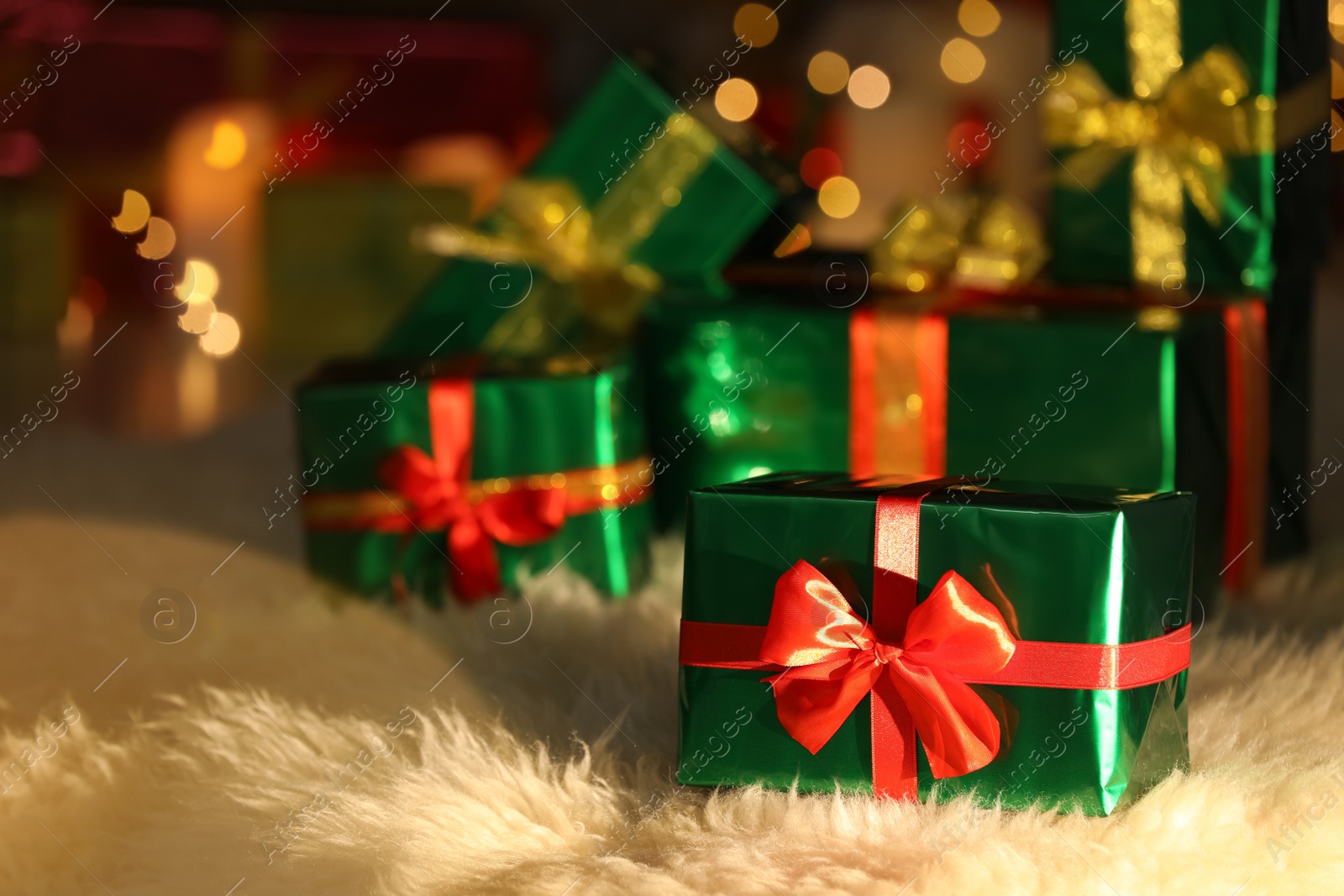 Photo of Beautiful Christmas gifts on furry carpet in room, space for text