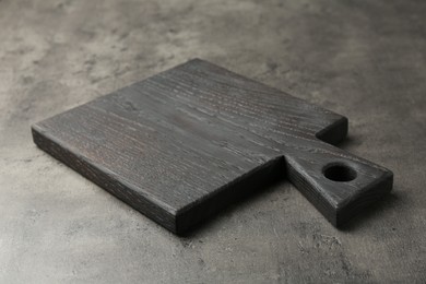 Photo of One black cutting board on grey table