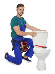 Young man working with toilet tank, isolated on white