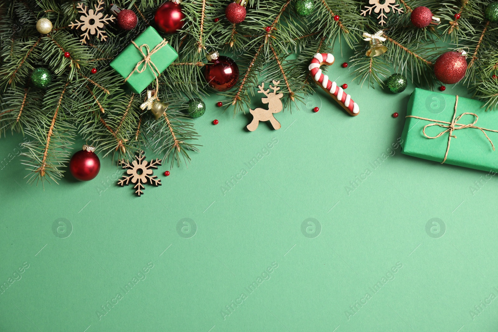 Photo of Fir tree branches with Christmas decoration on green background, flat lay. Space for text