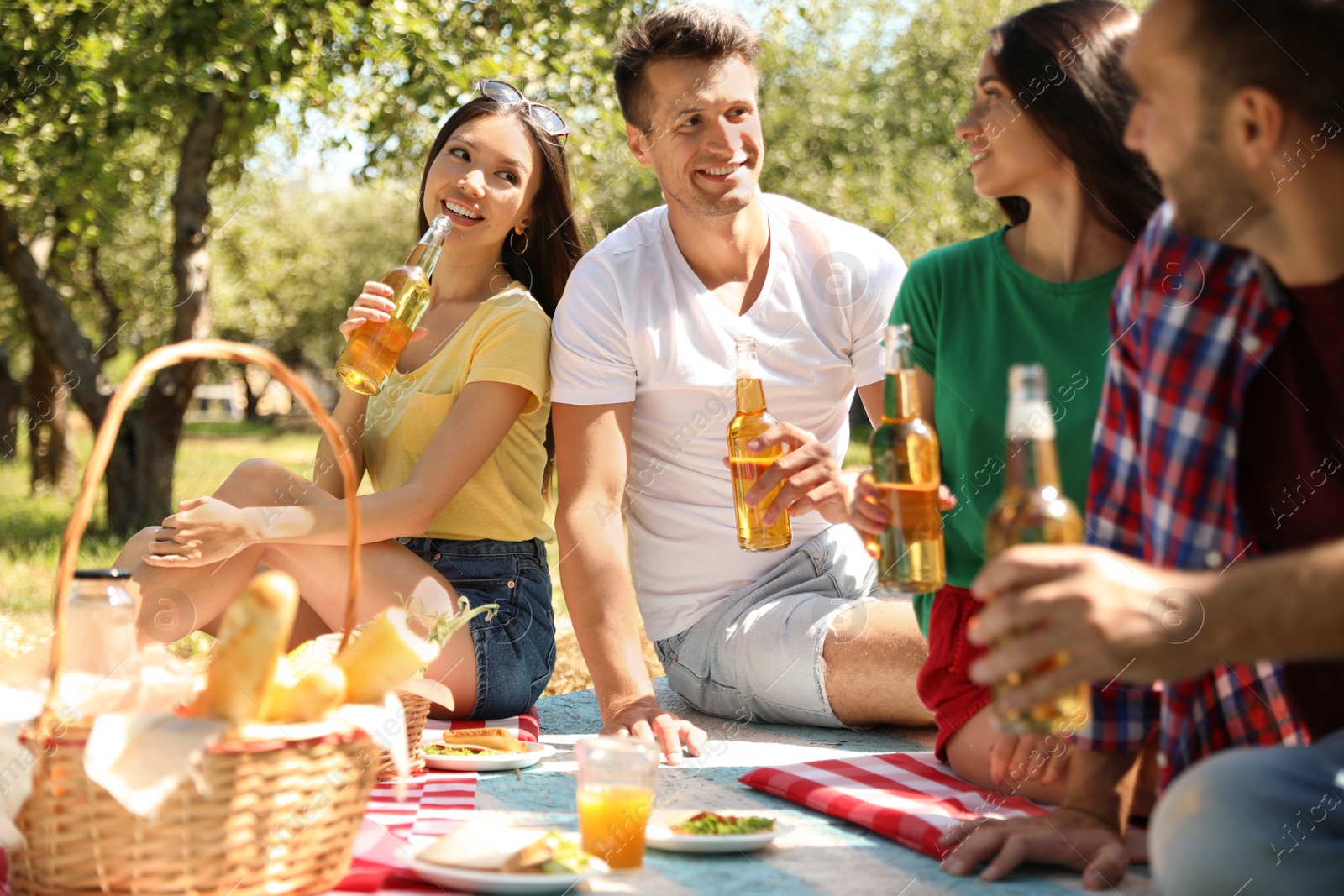 Photo of Young people enjoying picnic in park on summer day