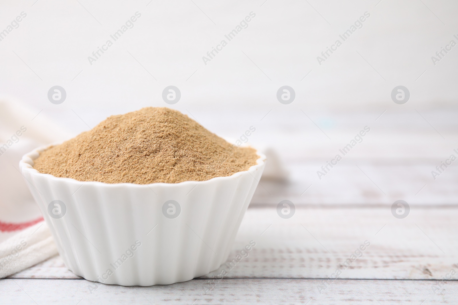 Photo of Dietary fiber. Psyllium husk powder in bowl on wooden table, space for text