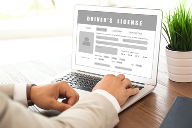 Man filling in driver's license form online on website using laptop, closeup