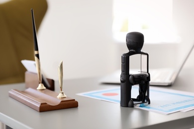 Photo of Automatic stamp and documents on desk in notary's office