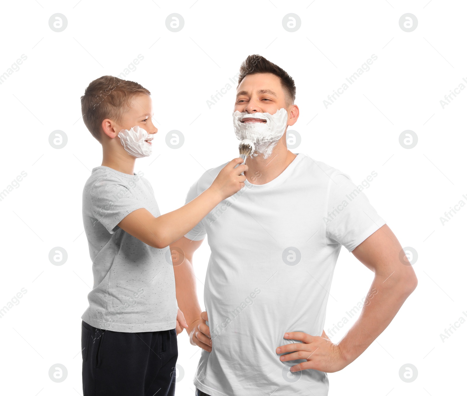 Photo of Son applying shaving foam on dad's face, white background