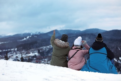 Friends enjoying mountain landscape, space for text. Winter vacation