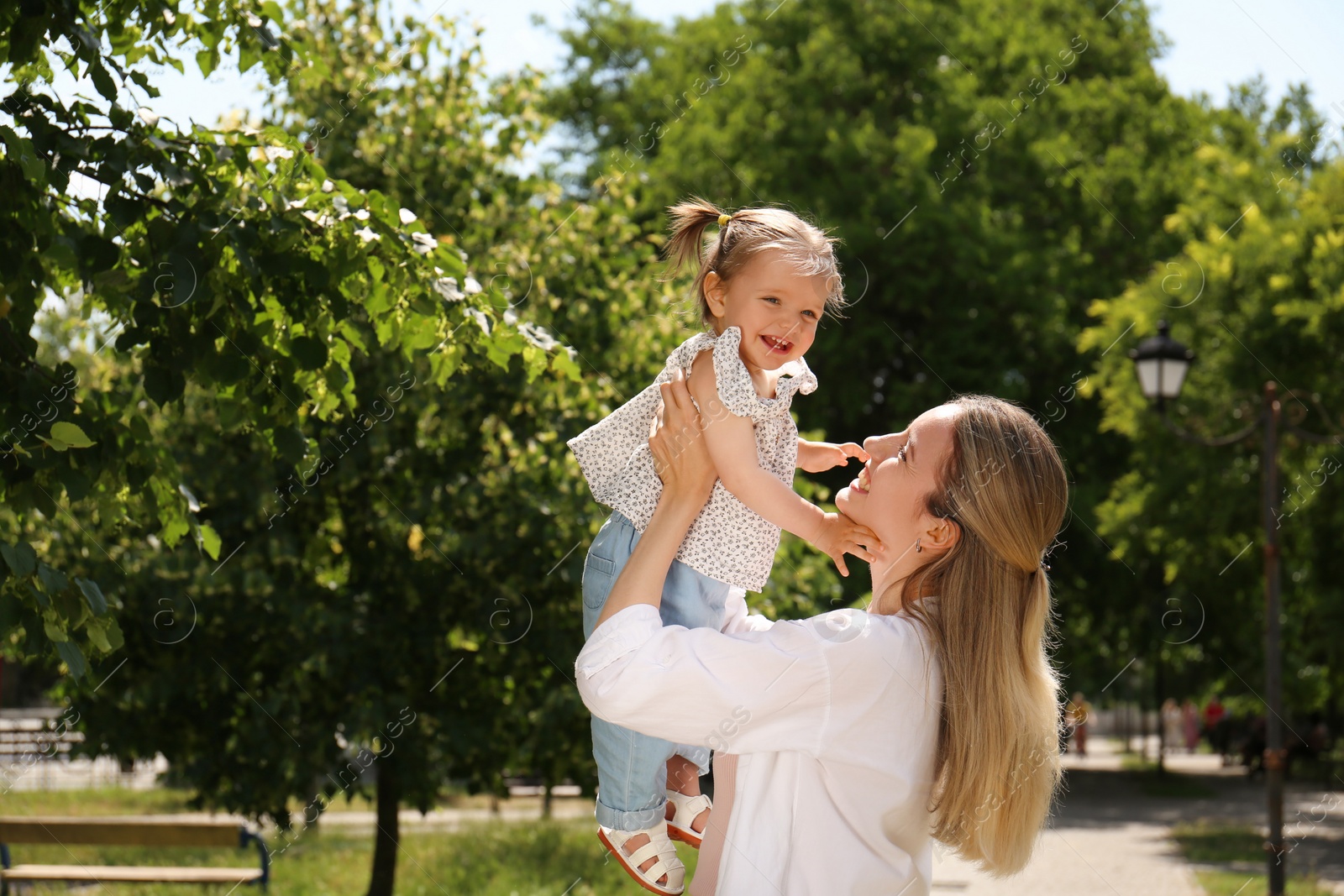 Photo of Happy mother with her daughter spending time together in park. Space for text