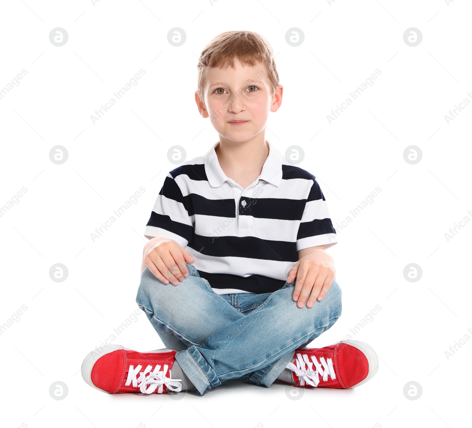 Photo of Cute little boy in casual outfit sitting on white background