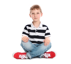 Cute little boy in casual outfit sitting on white background