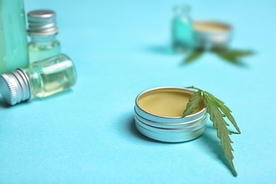 Photo of Jar with hemp lotion on color background