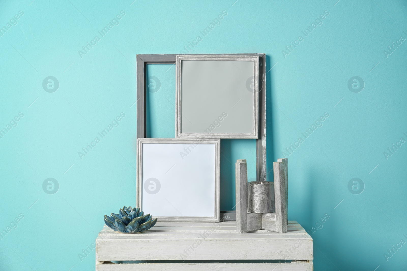 Photo of Mockup of blank frames and candle on table