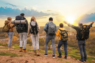 Photo of Group of hikers with backpacks in mountains, back view