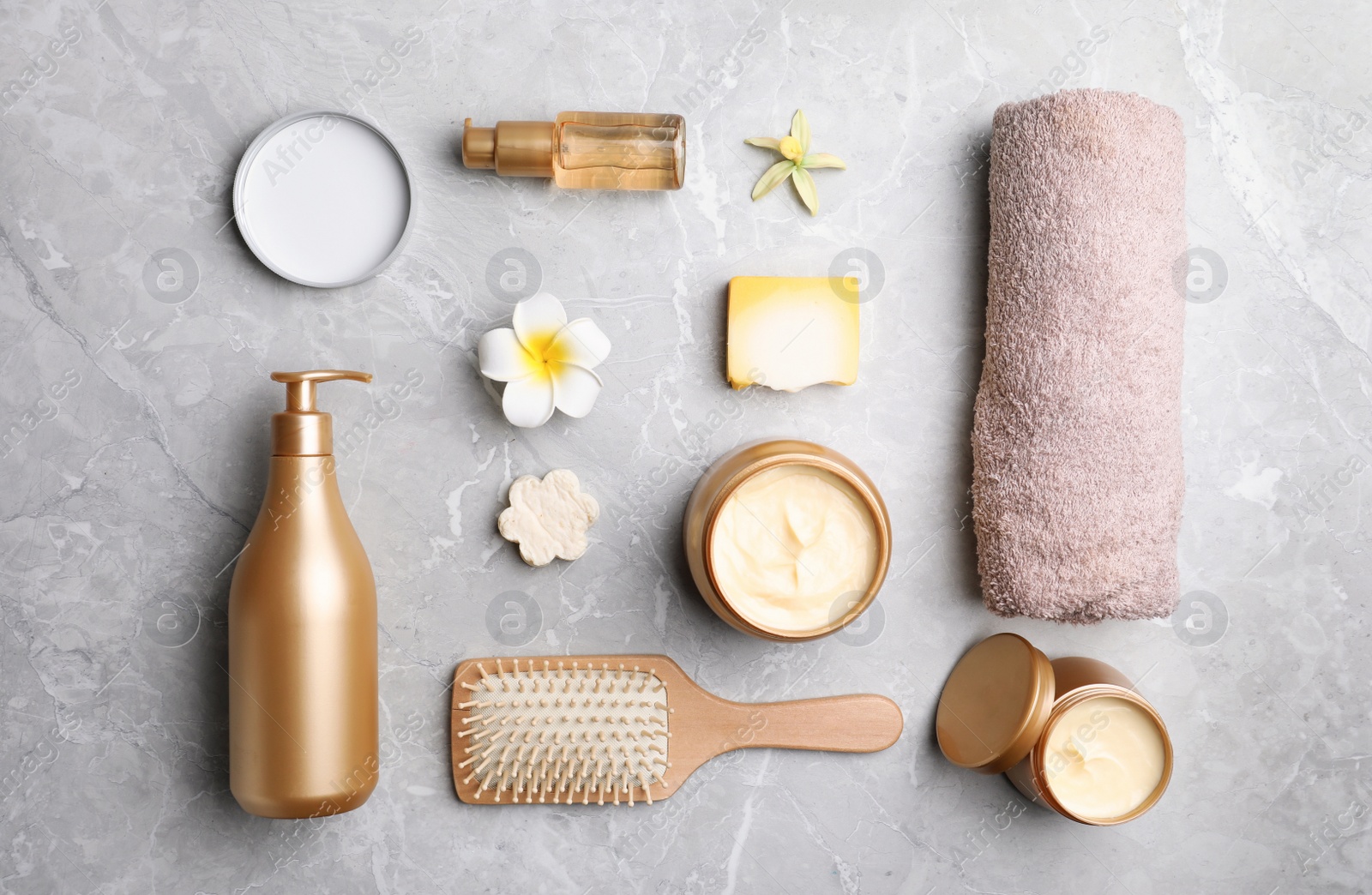 Photo of Flat lay composition with hair cosmetic products on grey marble table