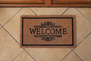 Photo of Door mat with word Welcome on floor, above view