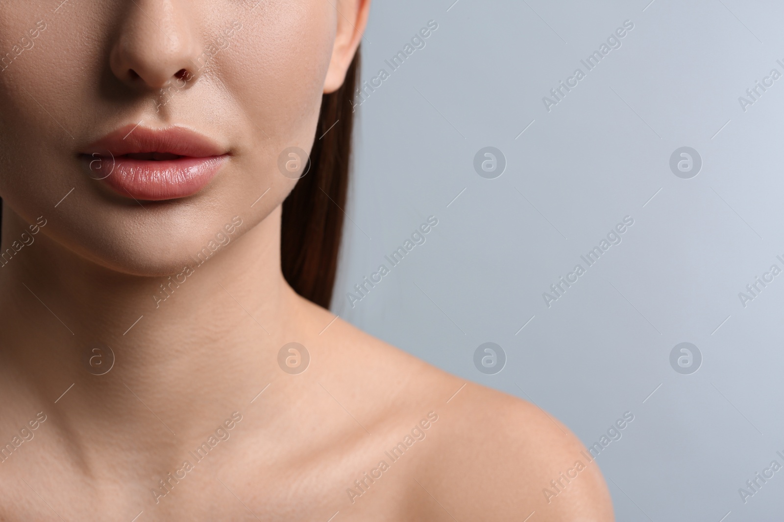 Photo of Woman with beautiful lips on light grey background, closeup. Space for text