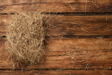 Dried hay on wooden background, top view. Space for text