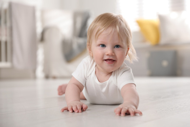 Photo of Cute little baby on floor at home