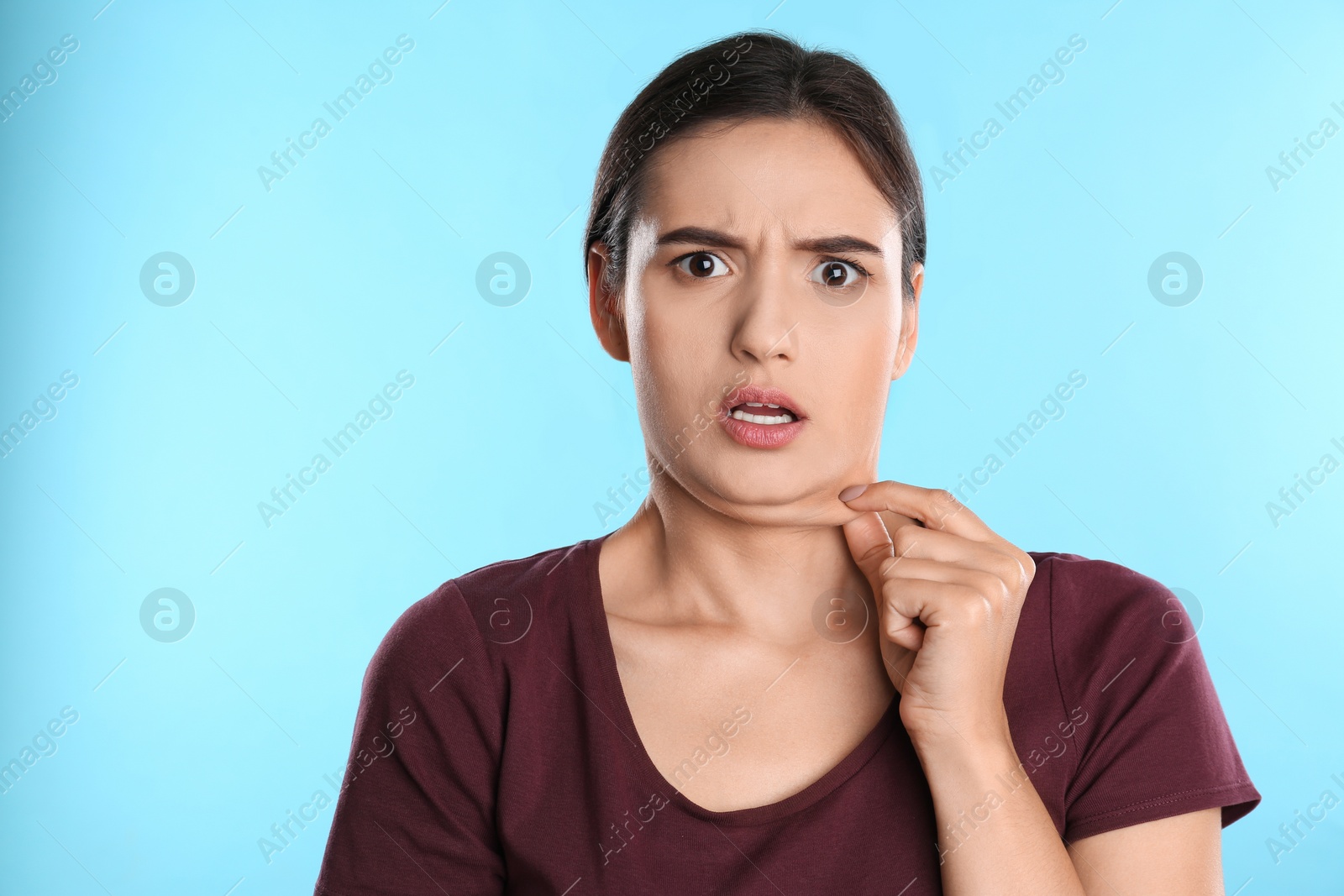 Photo of Emotional young woman with double chin on blue background