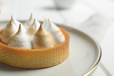 Photo of Tartlet with meringue on white table, closeup and space for text. Delicious dessert