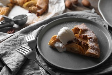 Delicious apple galette served with ice cream on wooden table, closeup