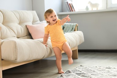 Cute baby learning to walk in living room