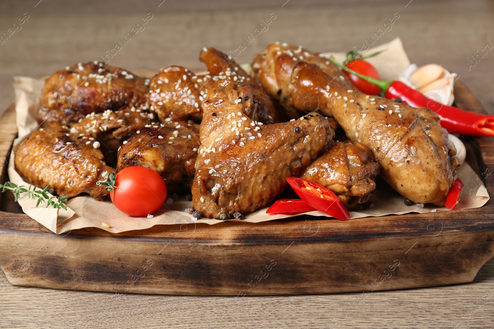 Photo of Tasty chicken glazed in soy sauce served on wooden table, closeup