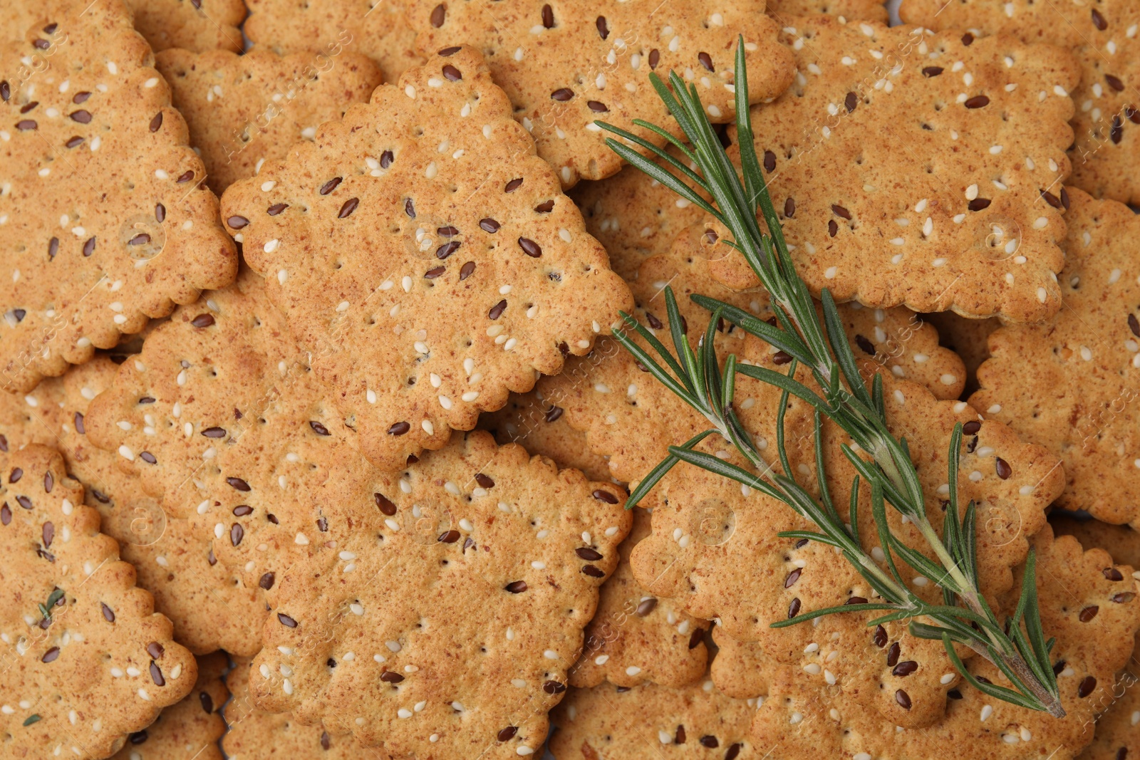 Photo of Rosemary on cereal crackers with flax and sesame seeds, top view