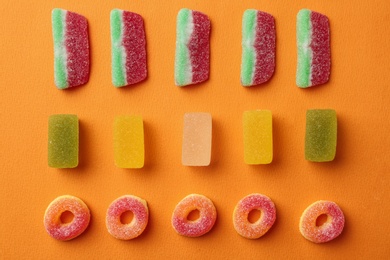 Photo of Flat lay composition with delicious jelly candies on color background