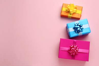 Photo of Bright gift boxes on pink background, flat lay. Space for text