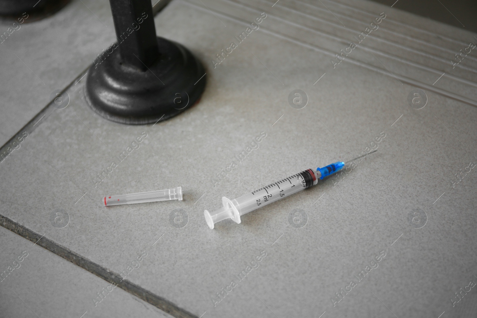 Photo of Disposable syringe with needle on tiled surface