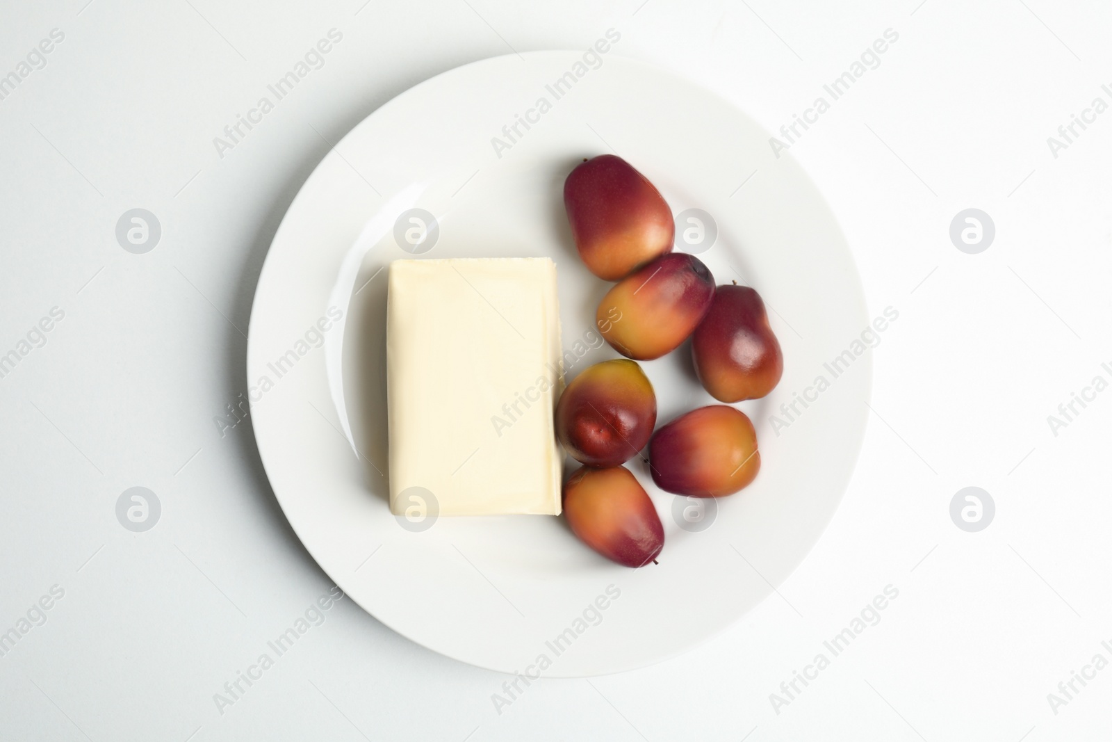Image of Plate with butter and palm oil fruits isolated on white, top view