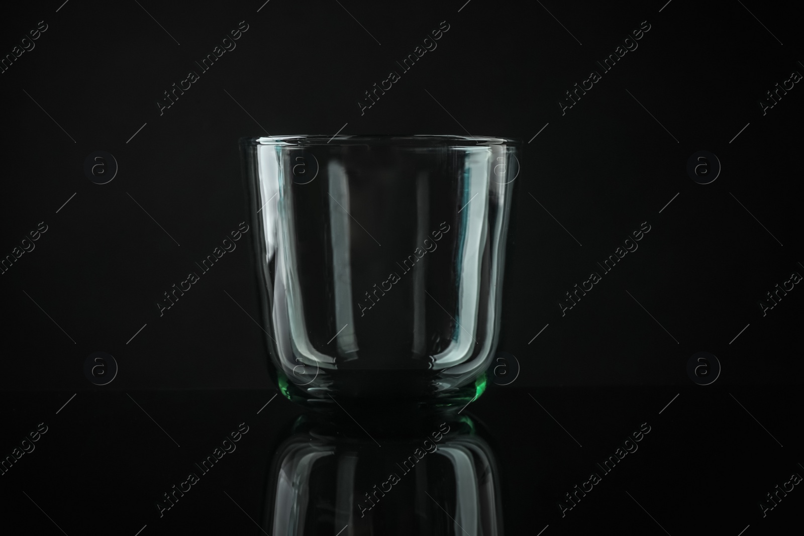 Photo of Elegant empty colorful whiskey glass on black background