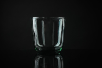 Photo of Elegant empty colorful whiskey glass on black background