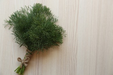 Photo of Bunch of dill on white wooden table, top view. Space for text
