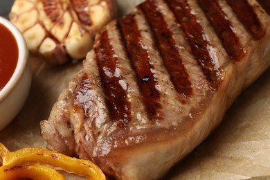 Photo of Delicious grilled beef steak with spices on parchment paper, closeup