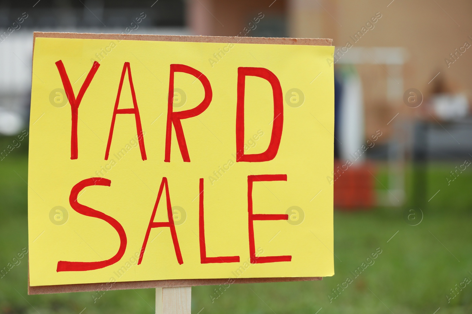 Photo of Sign Yard sale written on yellow paper outdoors, closeup